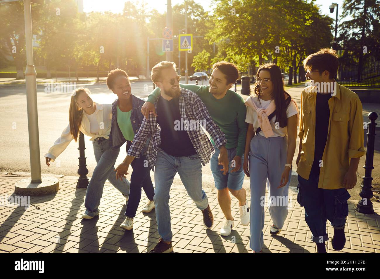 Diverse group of happy friends hanging out in the city, walking together and having fun Stock Photo