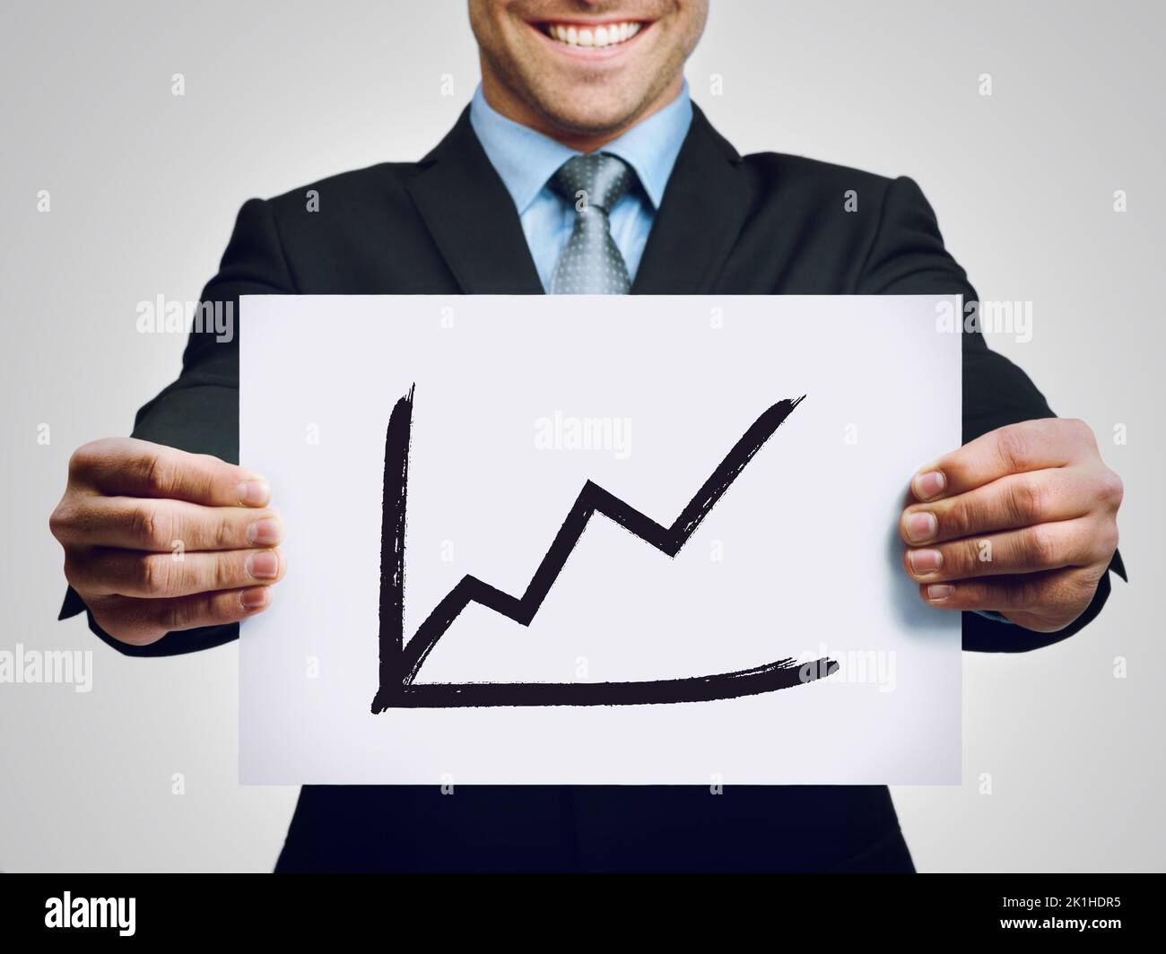 The numbers are in. a businessman holding up a hand-drawn profit graph. Stock Photo