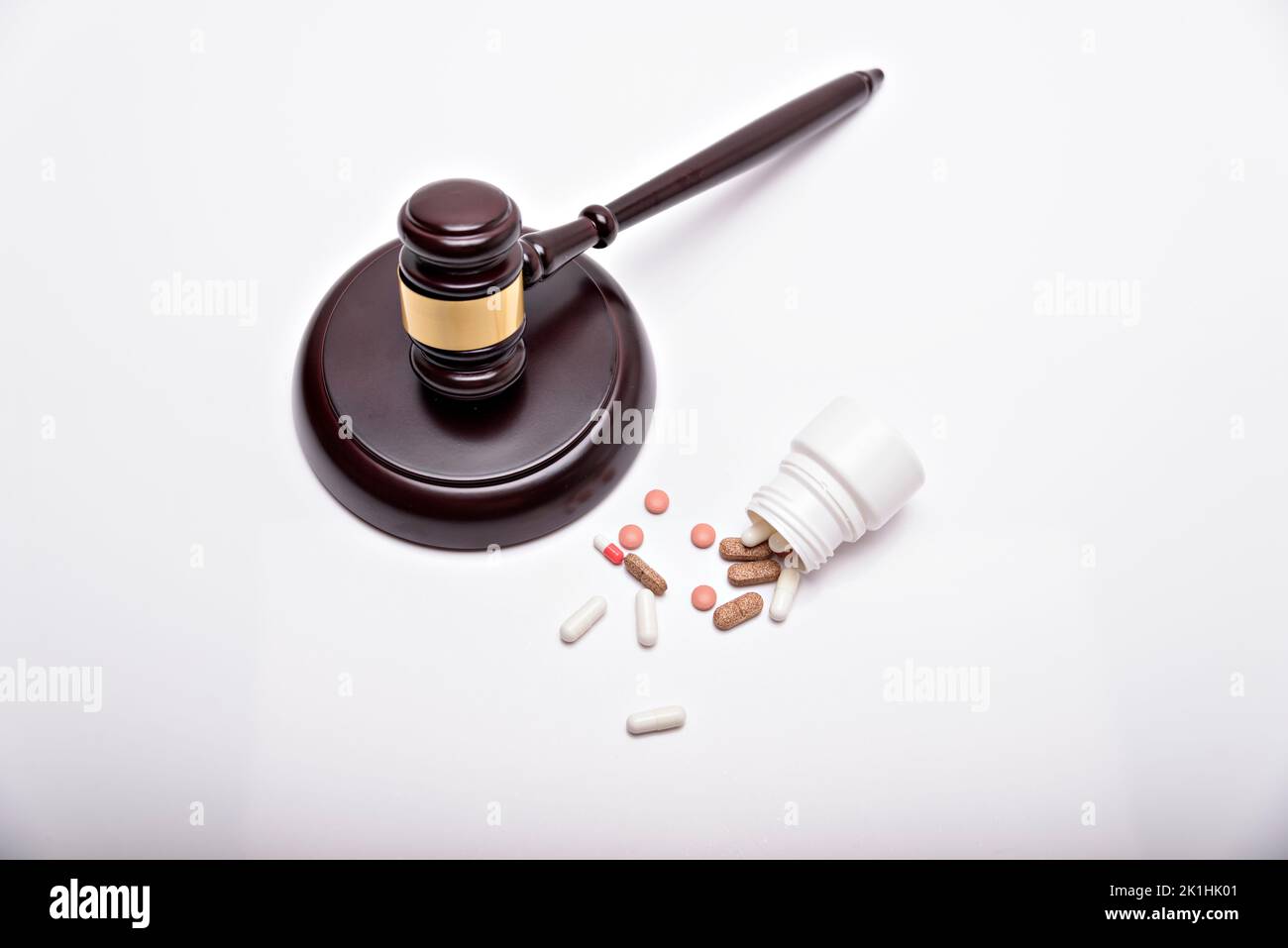 Medicine and law. Pills capsules and judge gavel isolated on white background. Stock Photo