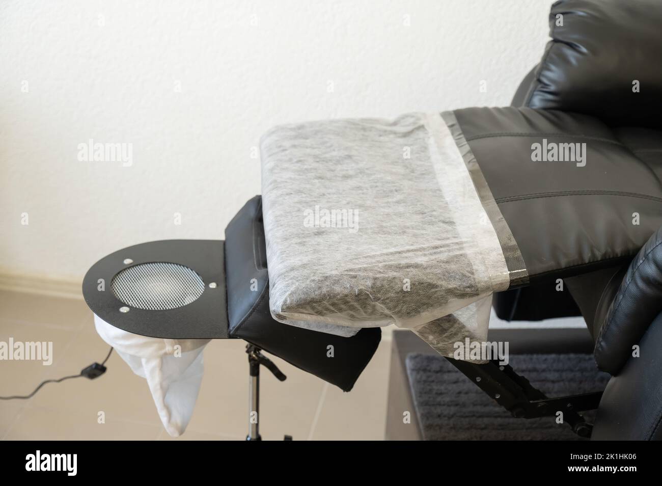 Black pedicure chair with dust vacuum cleaner in beauty salon Stock