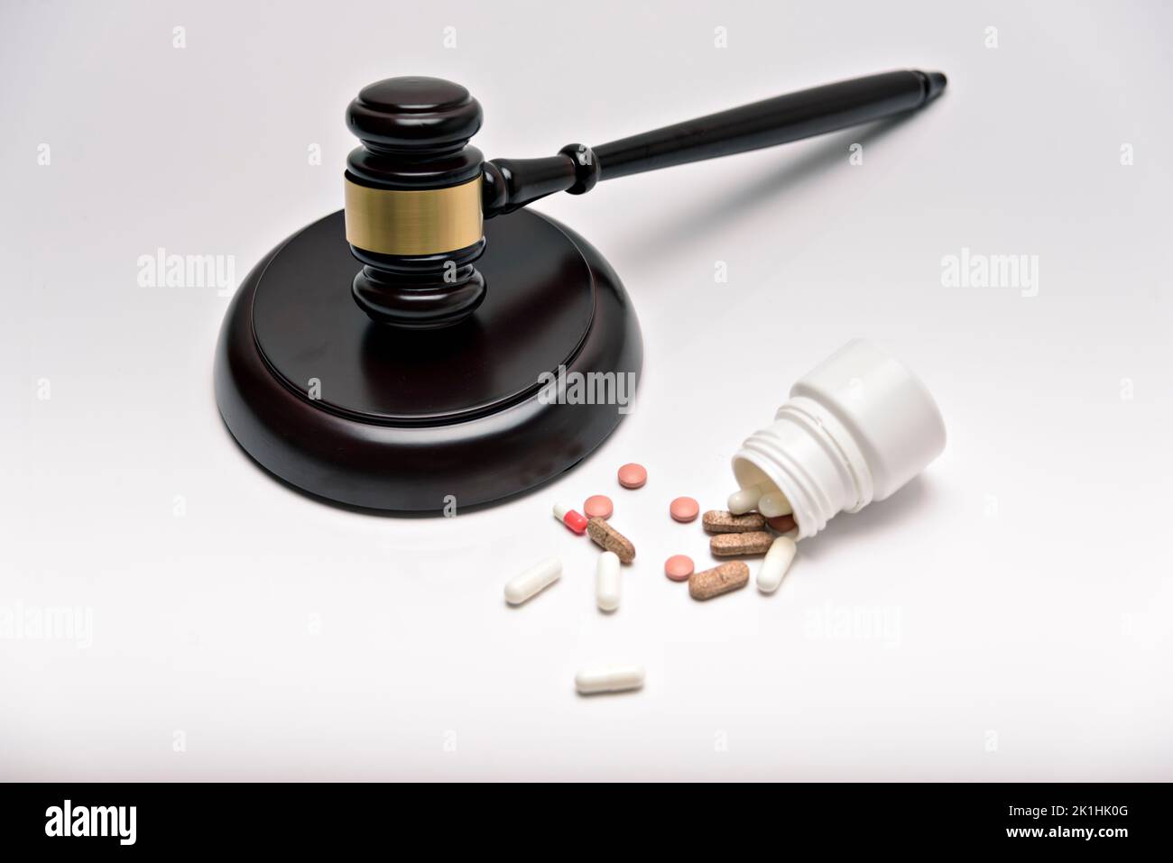 Medicine and law. Pills capsules and judge gavel isolated on white background. Stock Photo