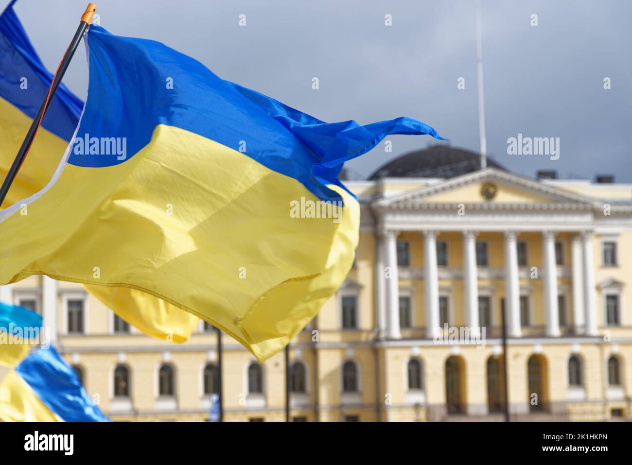 Helsinki, Finland - March 26, 2022: Ukrainian flags with the Finnish Government Palace behind on the background in a rally against Russias military ac Stock Photo