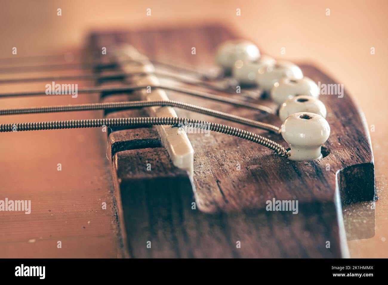 Acoustic guitar bridge and strings close up Stock Photo - Alamy