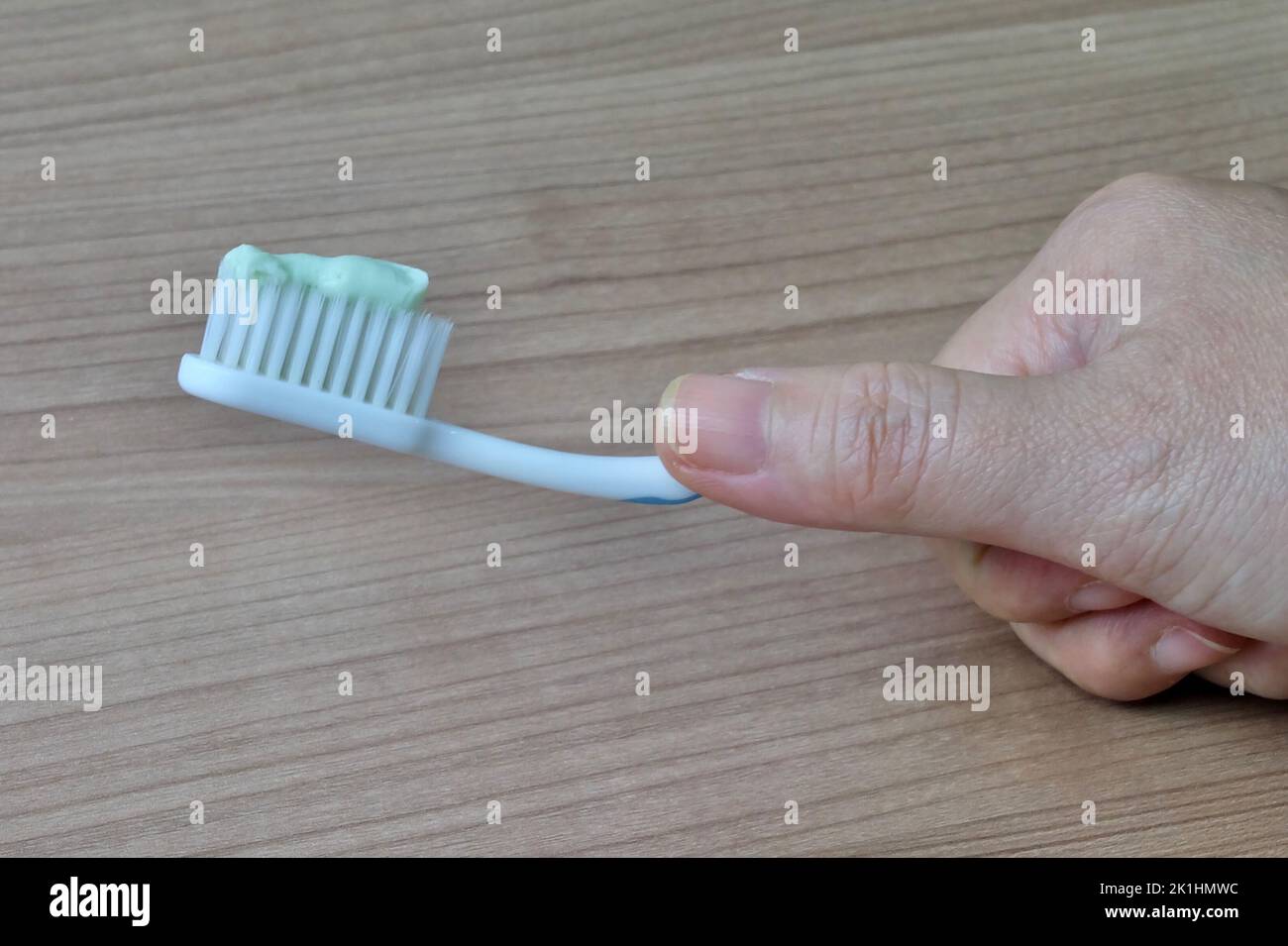 Hand Holding Toothbrushes with Toothpaste. An Oral Hygiene Instrument
