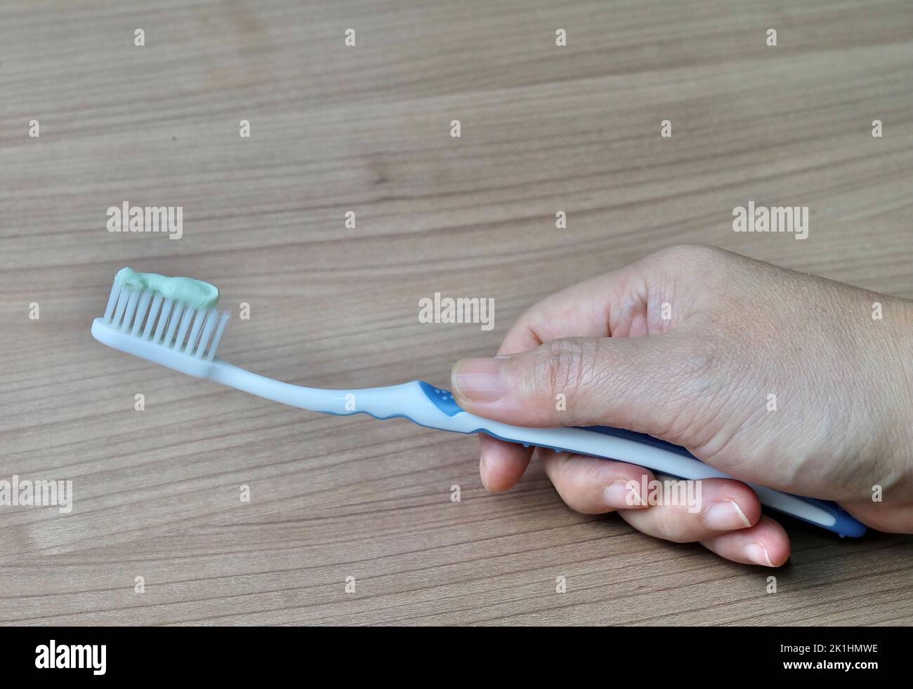 Hand Holding Toothbrushes with Toothpaste. An Oral Hygiene Instrument