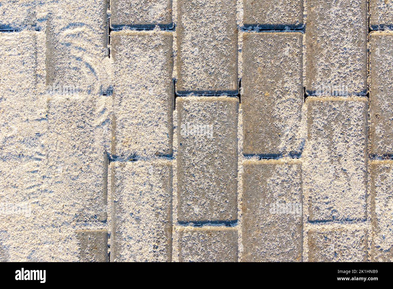 paving slabs made of artificial stone at the stage of filling the joints with dry sifted sand, selective focus Stock Photo