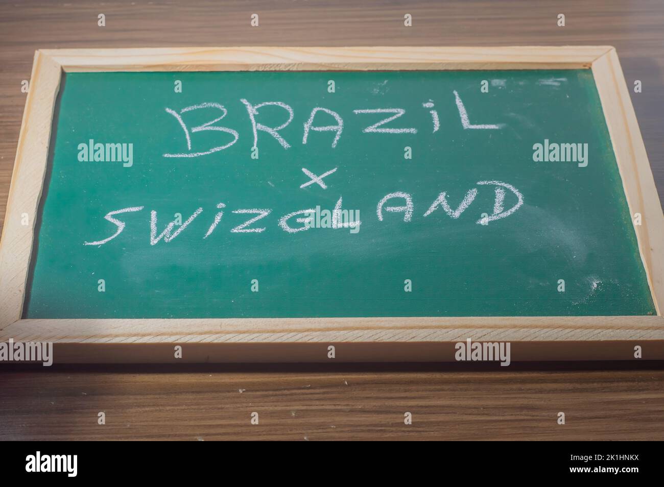 Green chalkboard written 'Brazil x swzeland' with a white chalk,concept of confrontation between country,football. Stock Photo