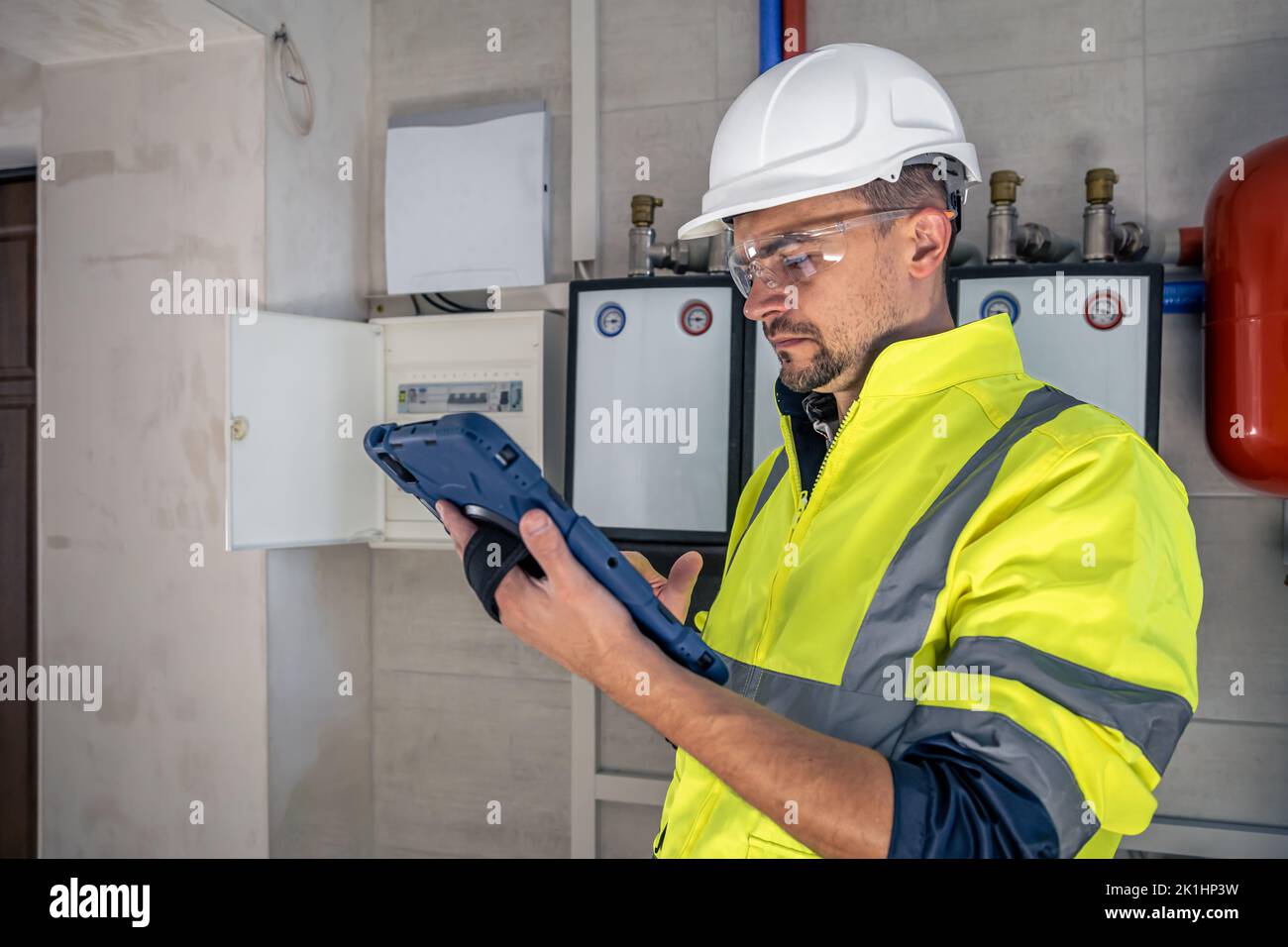 Electrical technician looking focused while working in a switchboard with fuses. Stock Photo