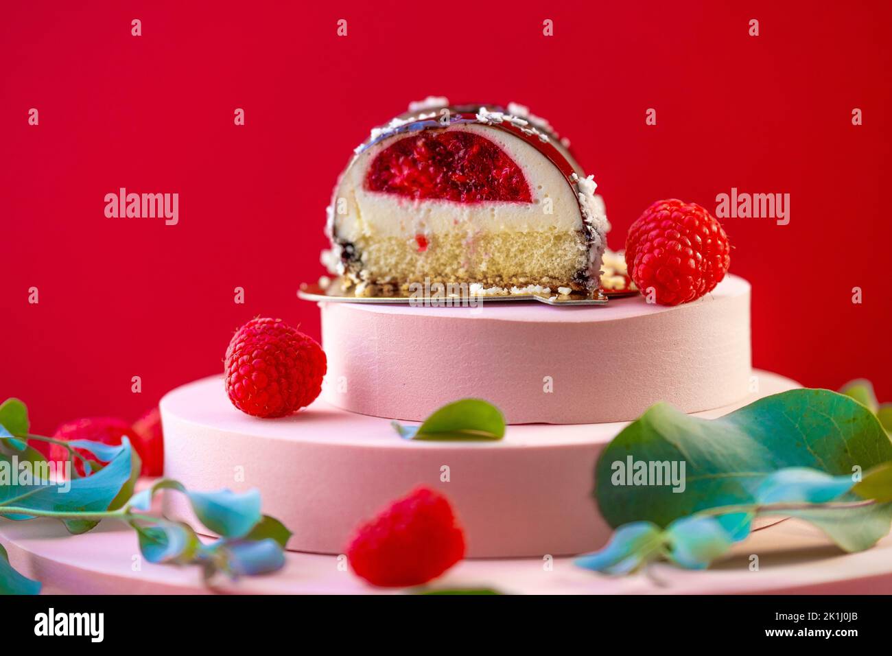 Chocolate round cake with raspberry filling cut and raspberries on a ...