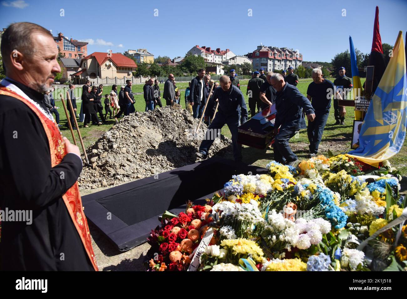 Undertakers lower the coffin with the body of Captain Volodymyr Ivanyuk ...