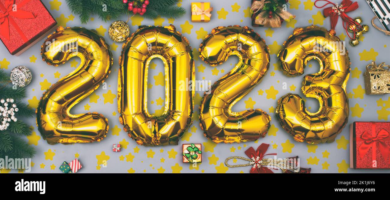 Happy New year 2023 celebration. Foil balloons numeral 2023 and with Glitter Stars .Flat lay. Merry Christmas and Happy Holidays greeting card, frame, Stock Photo