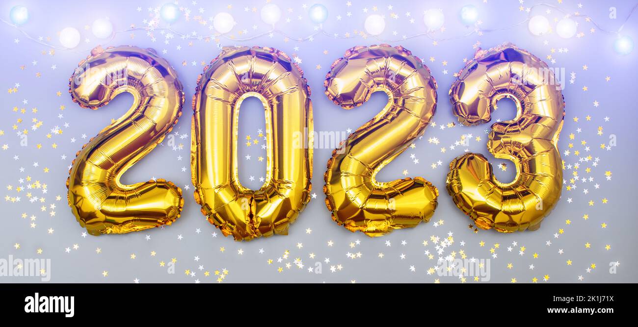 Happy New year 2023 celebration. Foil balloons numeral 2023 and with Glitter Stars .Flat lay Stock Photo