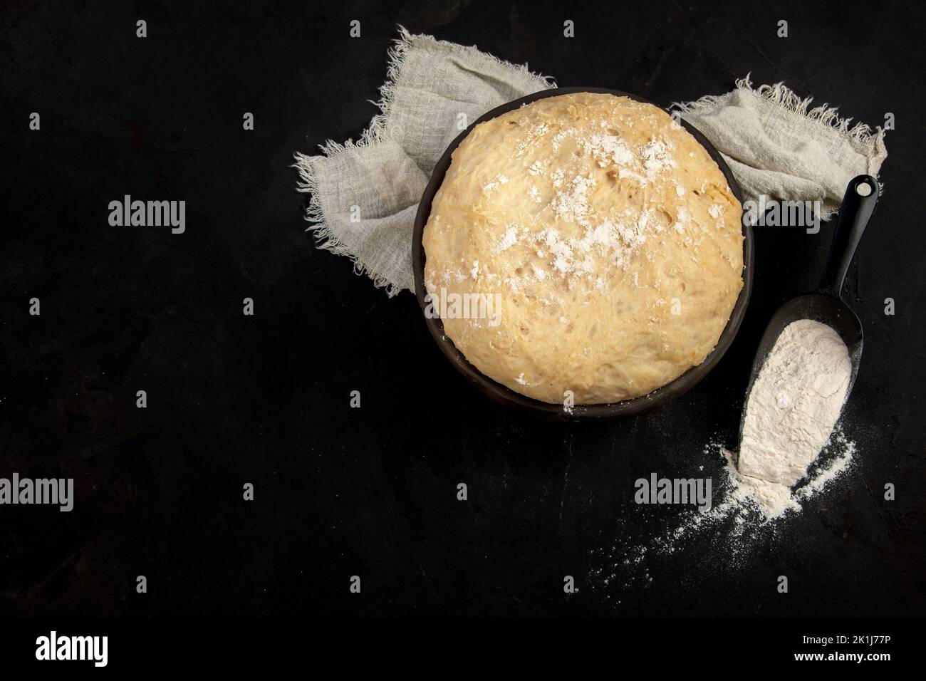 Raw dough pastry in a bowl on dark background. Homemade bio food concept. Top view, copy space Stock Photo