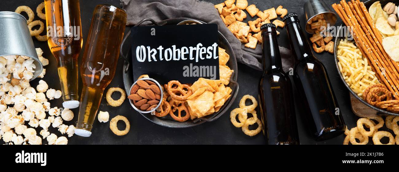 Assortment of beer and salty snacks on dark background. Party food concept. Top view, panorama Stock Photo