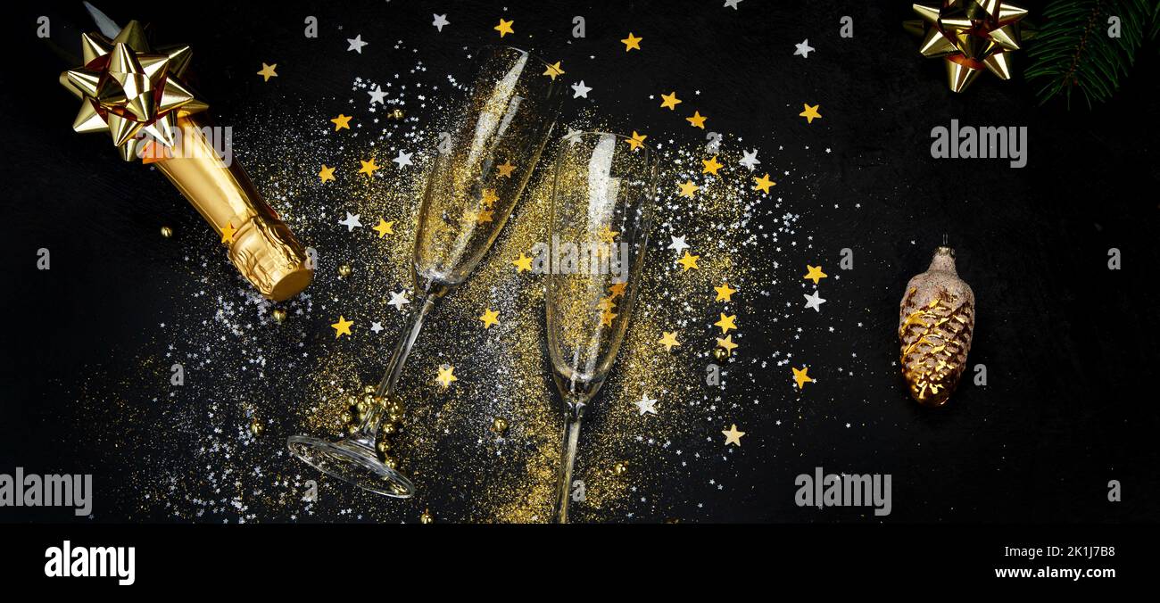 Glass of champagne and bottle on dark background. Traditional festive time drinks. Top view Stock Photo