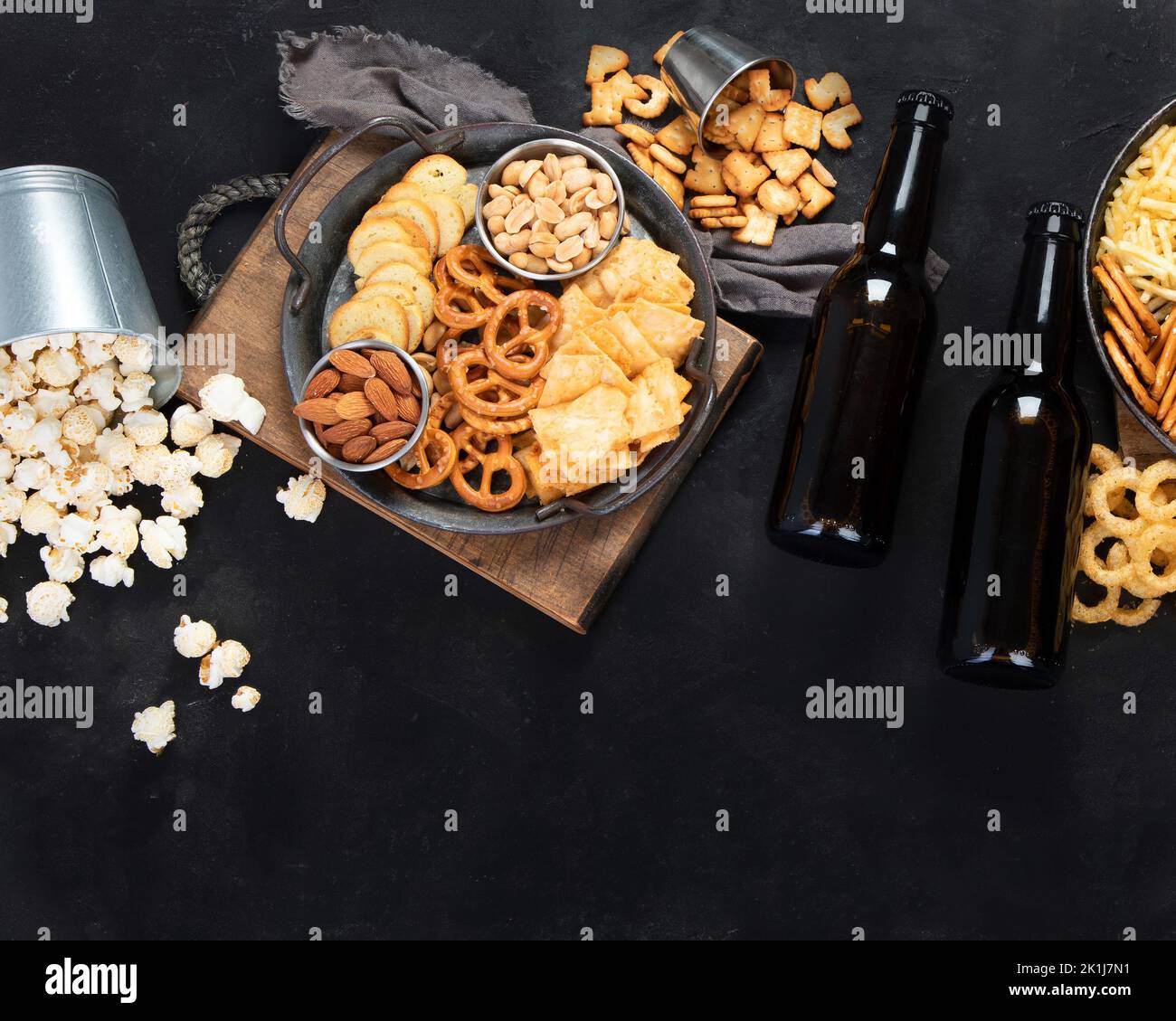 Assortment of beer and salty snacks on dark background. Party food concept. Top view, copy space Stock Photo