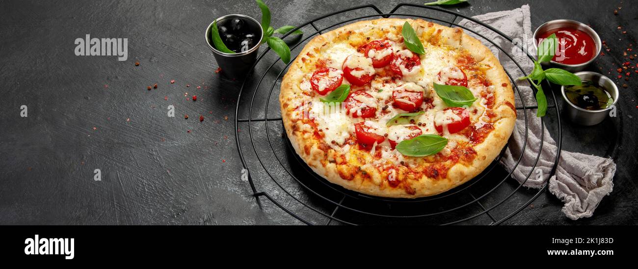 Freshly baked pizza on dark background. Tasty homemade food concept. panorama, copy space Stock Photo