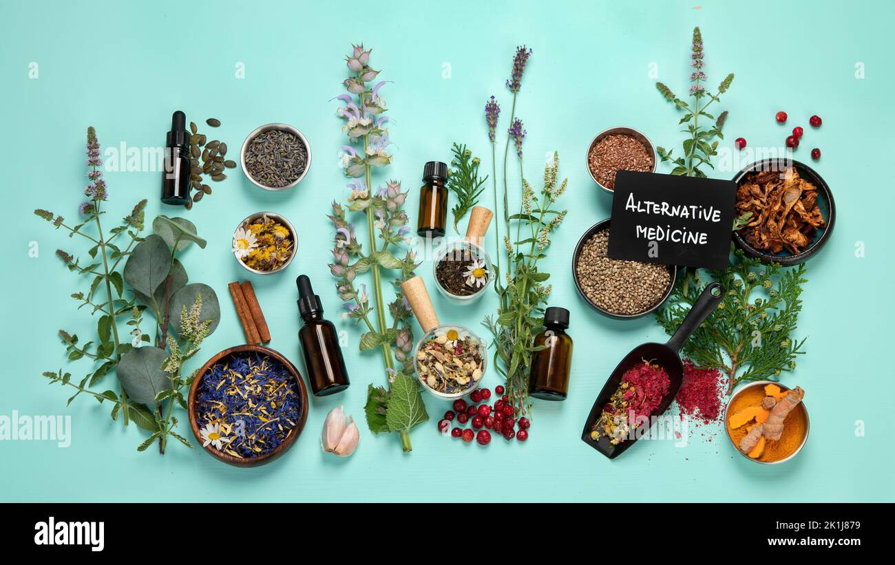 Alternative herbal medicine on green background. Homeopatic flower and herbs remedies. Top view Stock Photo