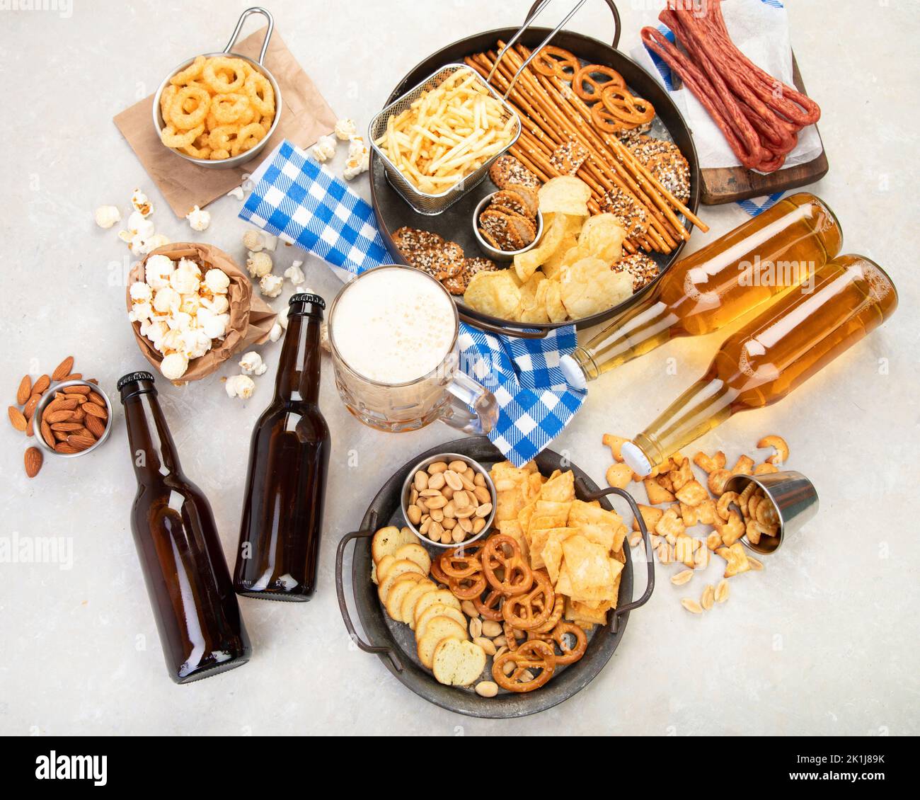 Assortment of beer and salty snacks on light background. Party food concept. Top view, copy space Stock Photo