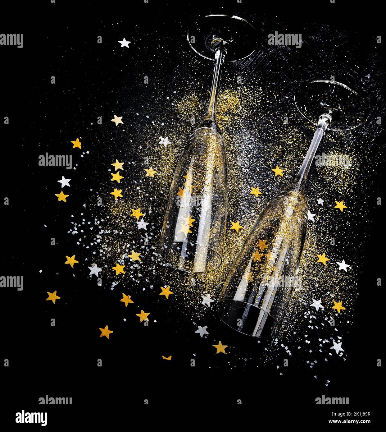 Two champagne glasses. Christmas decoration on a black background background. Happy New Year Celebration. Top view. Stock Photo