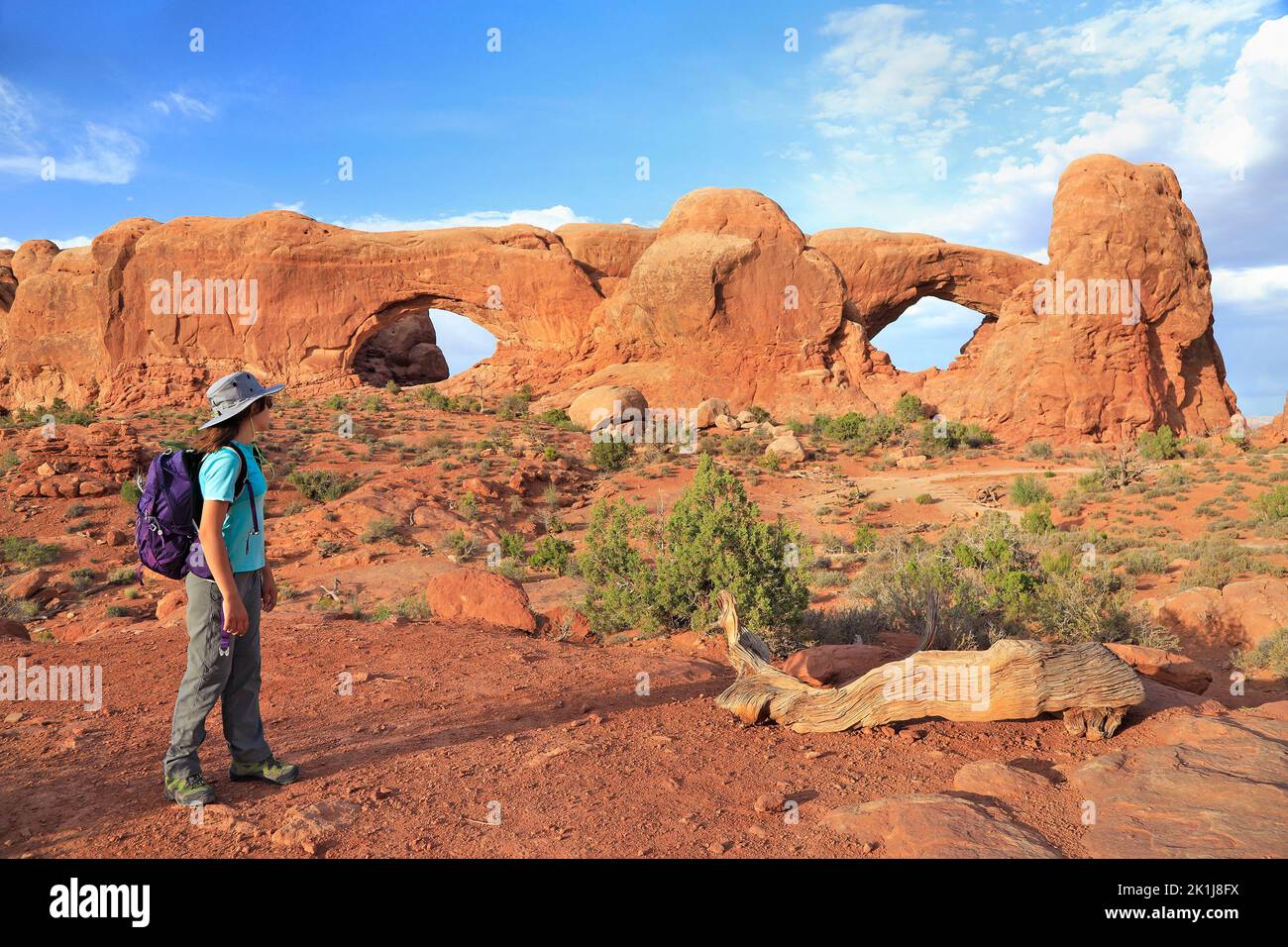 Young girl tourist admiring South and North Windows in Arches National Park, Utah, USA Stock Photo
