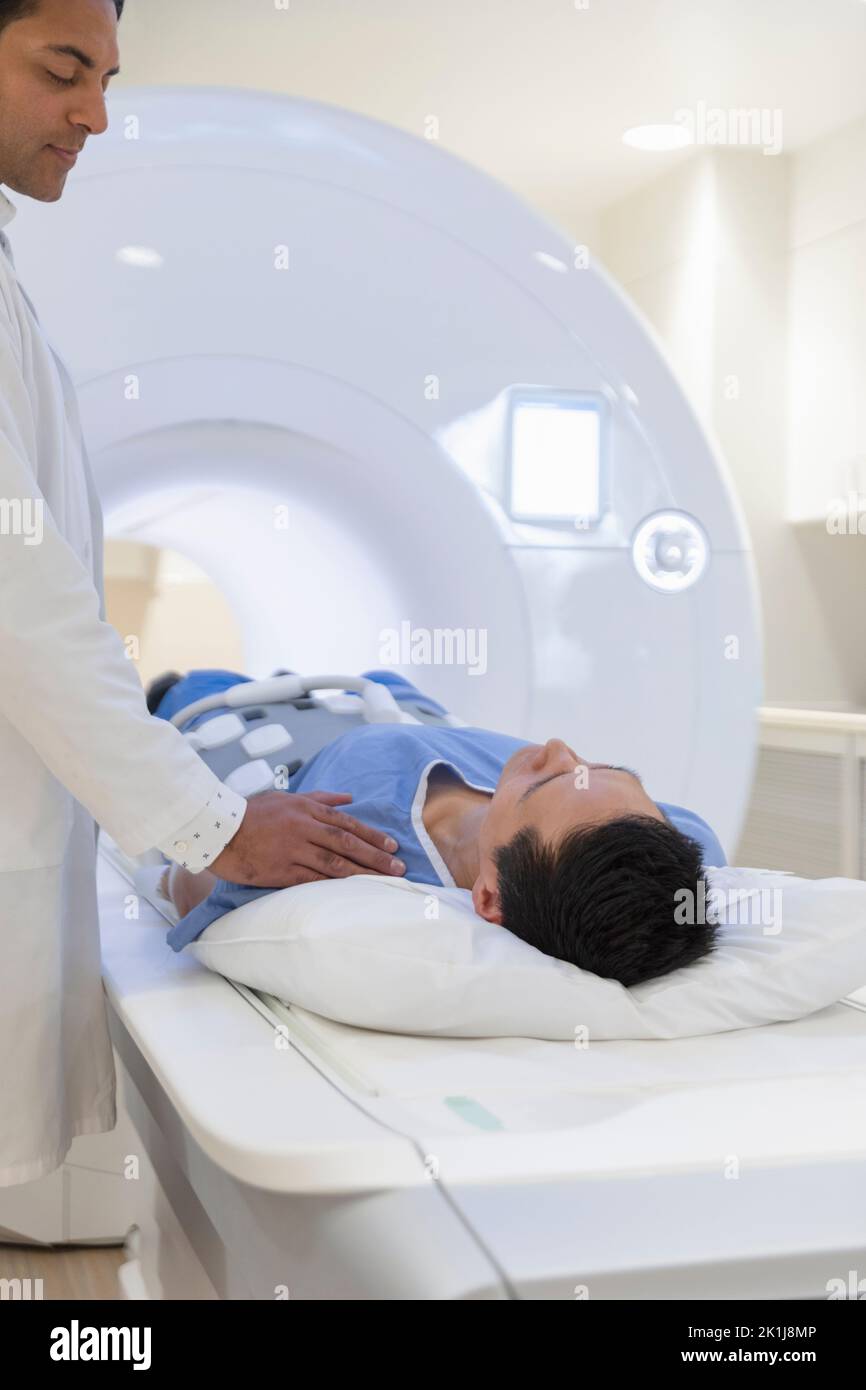 Radiology technologist preparing patient for MRI scan Stock Photo