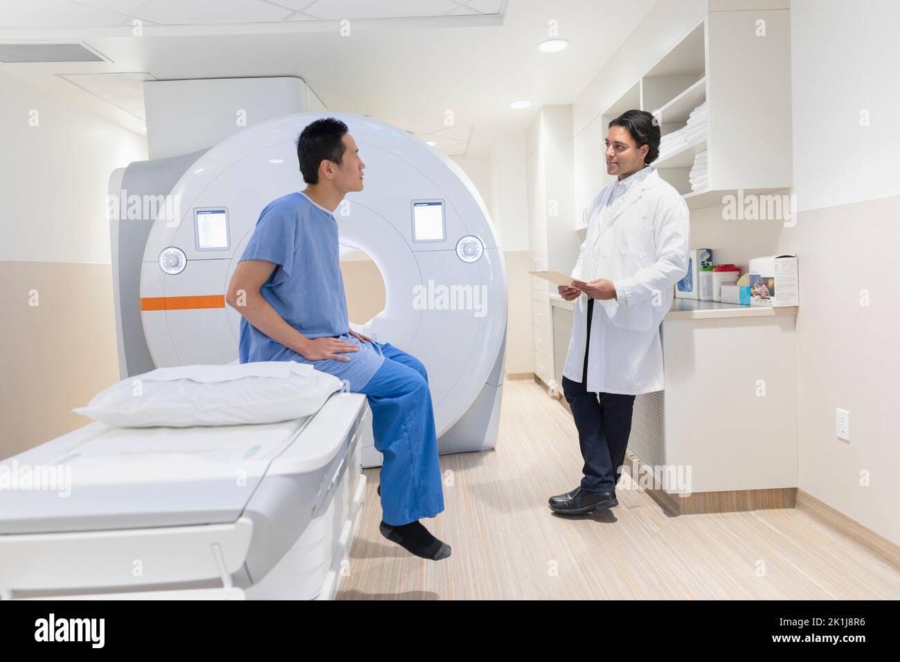 Radiology technologist talking to MRI scan patient Stock Photo