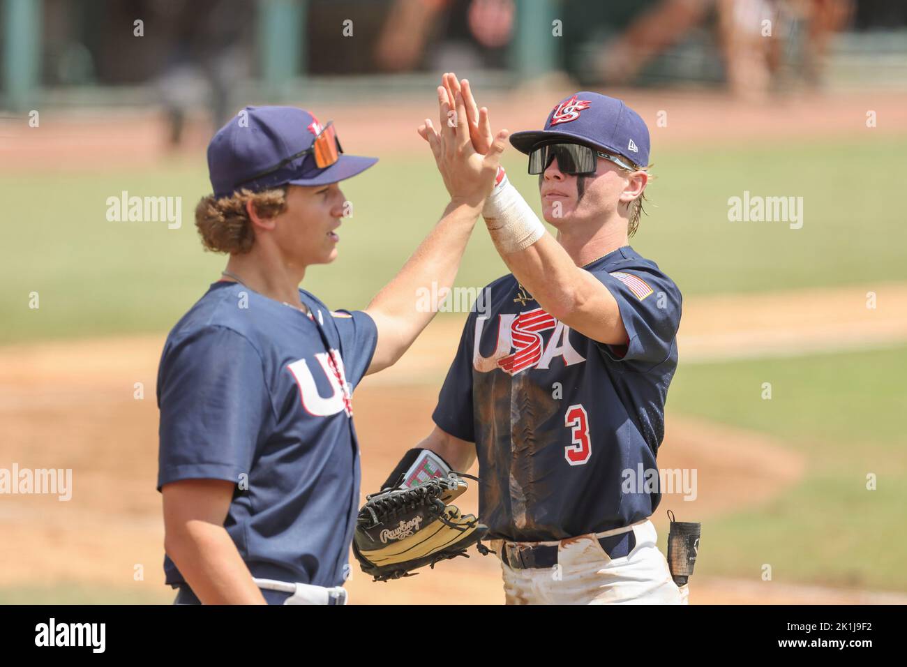 Sarasota, FL. USA;  Team USA pitcher Blake Mitchell (23) high fives Team USA lift fielder Max Clark (3) in the fifth inning during the Gold Medal Game Stock Photo