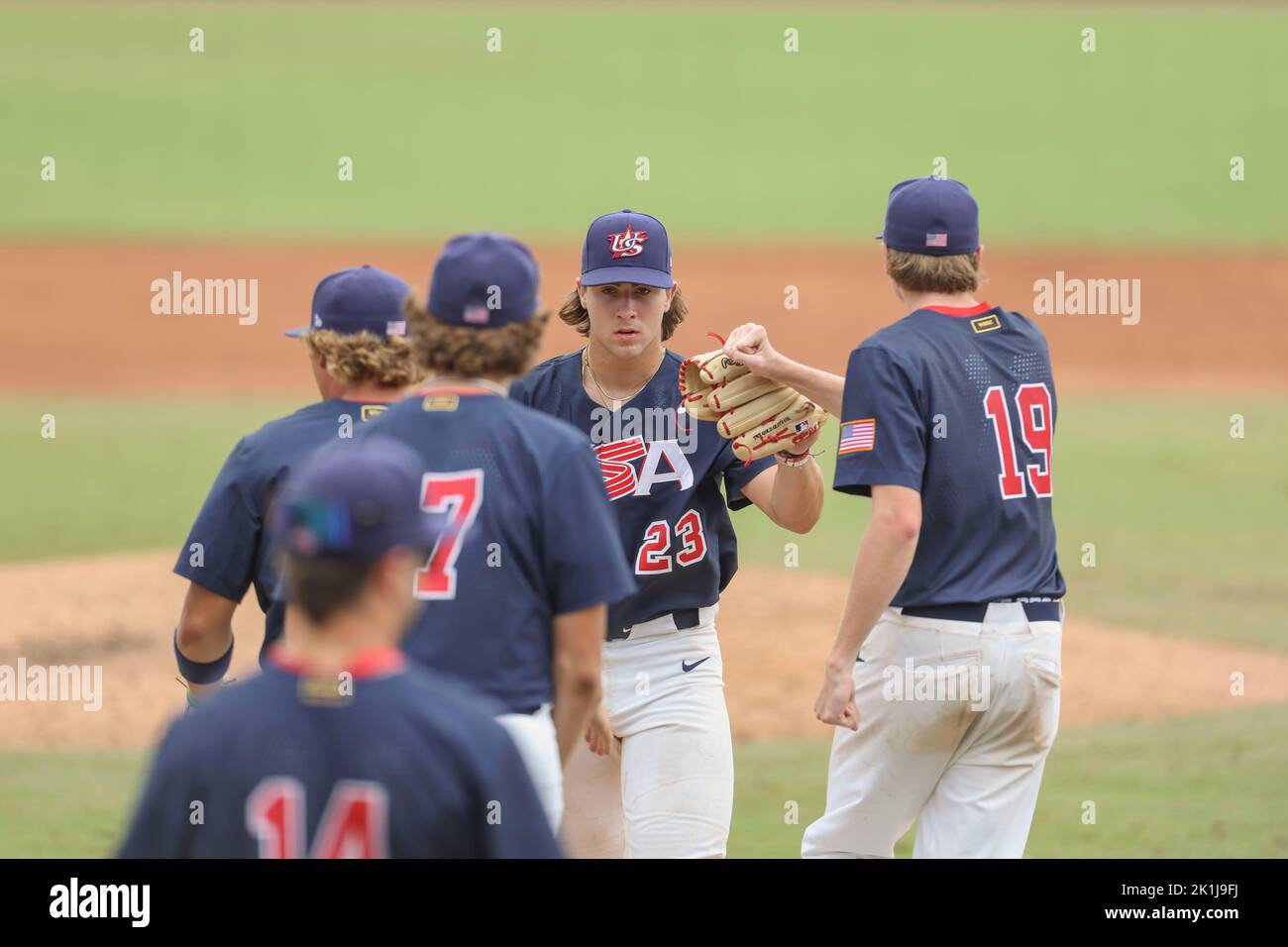 Sarasota, FL. USA;  Team USA Blake Mitchell (23) heads to the dugout after keeping Chinese Taipei off the scoreboard and is high fives by teammates du Stock Photo