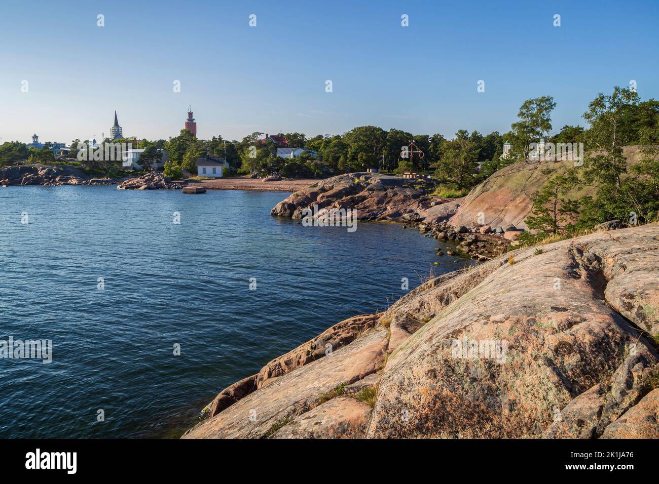 Rocky coastline and shoreline cliffs at Puistovuori and cityscape in Hanko, Finland, on a sunny day in the summer. Stock Photo