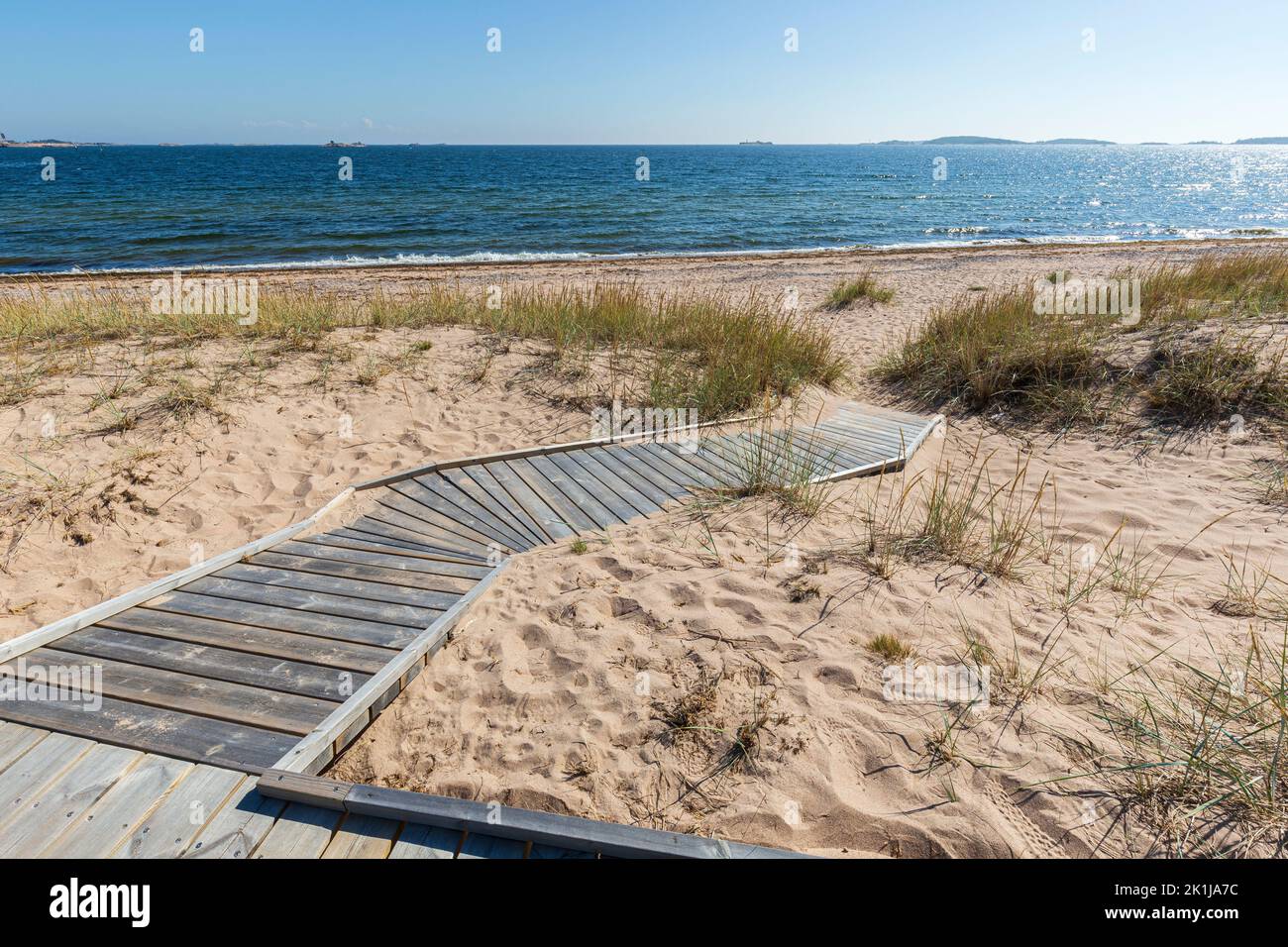 Wooden boardwalk at the empty Tulliniemi beach in Hanko, Finland, on a sunny day in the summer. Stock Photo
