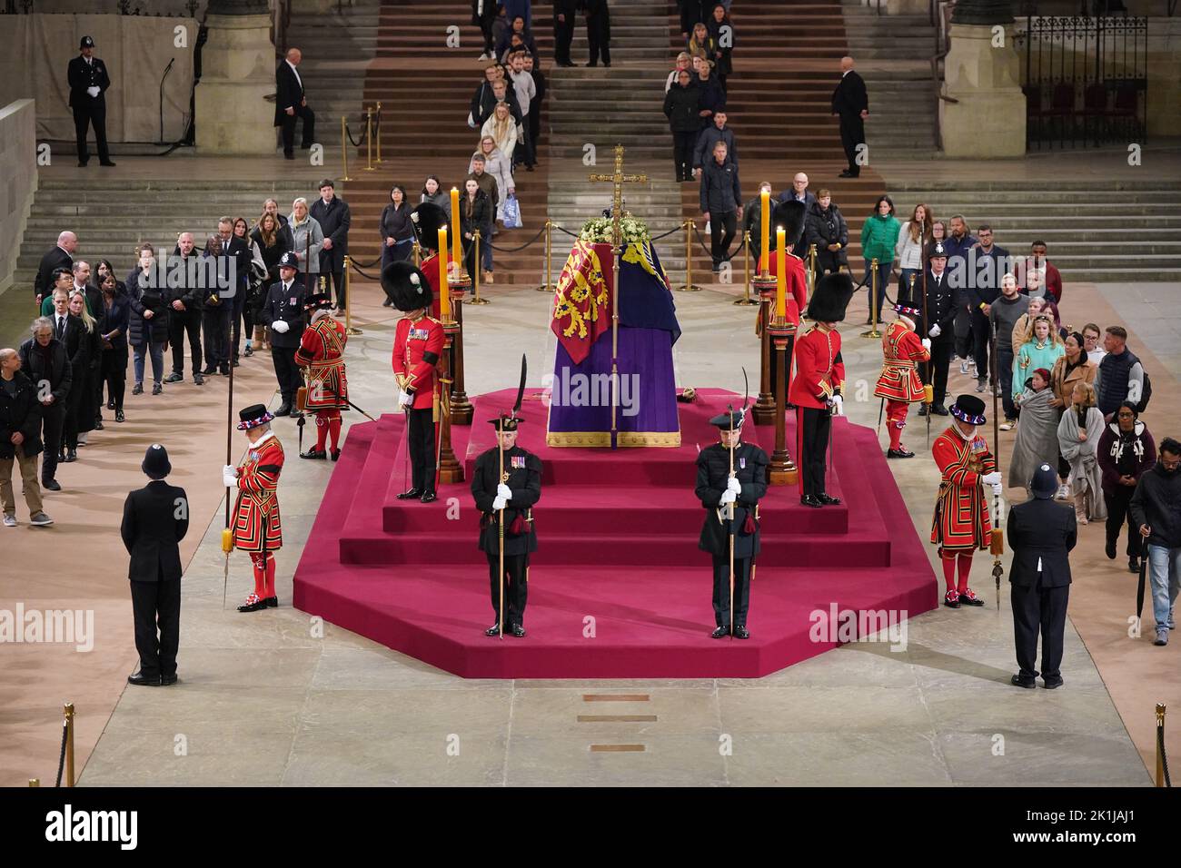 At 4.50am on the day of her funeral the final members of the public pay their respects at the coffin of Queen Elizabeth II, draped in the Royal Standard with the Imperial State Crown and the Sovereign's orb and sceptre, lying in state on the catafalque in Westminster Hall, at the Palace of Westminster, London. Picture date: Monday September 19, 2022. Stock Photo