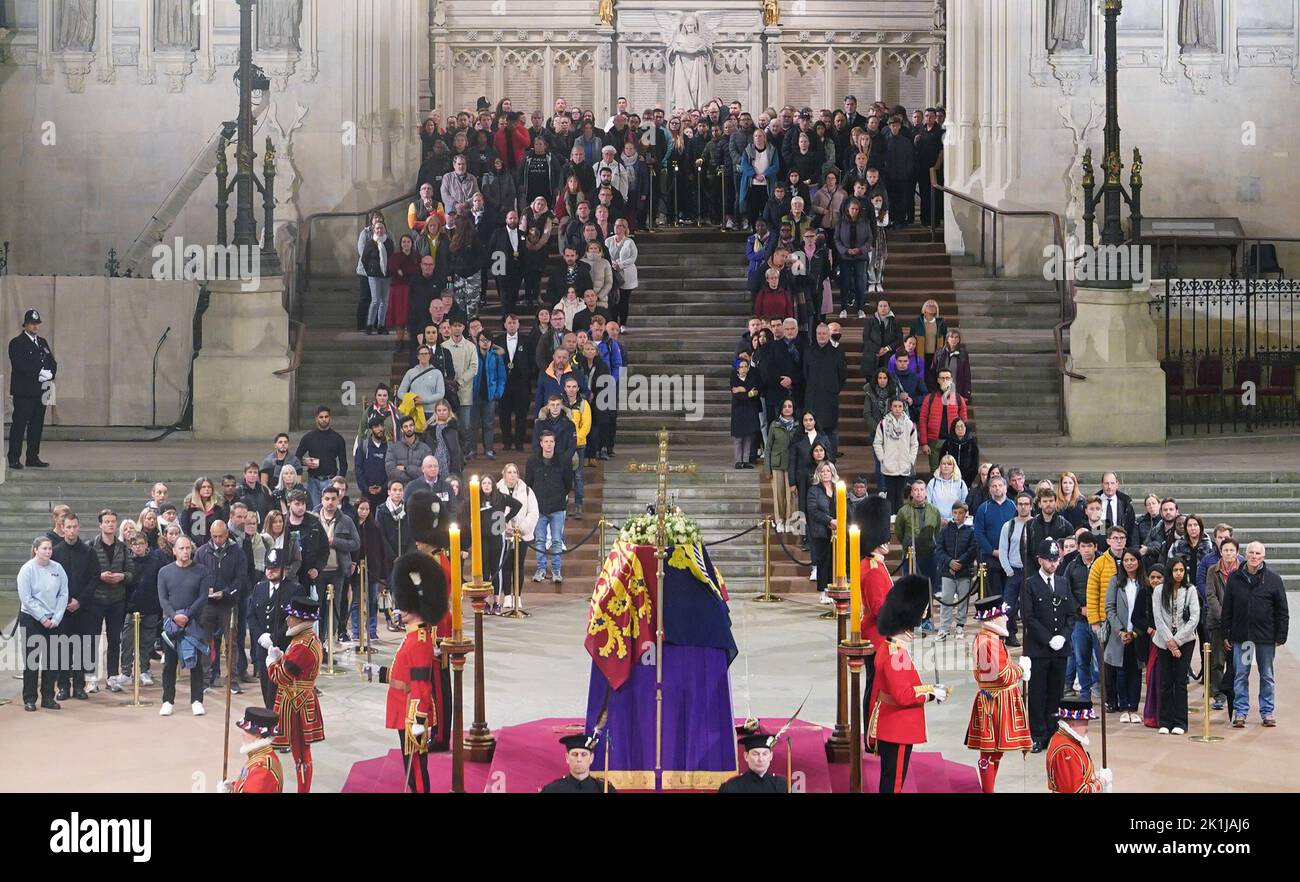 At 5.03am on the day of her funeral the final members of the public pay their respects at the coffin of Queen Elizabeth II, draped in the Royal Standard with the Imperial State Crown and the Sovereign's orb and sceptre, lying in state on the catafalque in Westminster Hall, at the Palace of Westminster, London. Picture date: Monday September 19, 2022. Stock Photo
