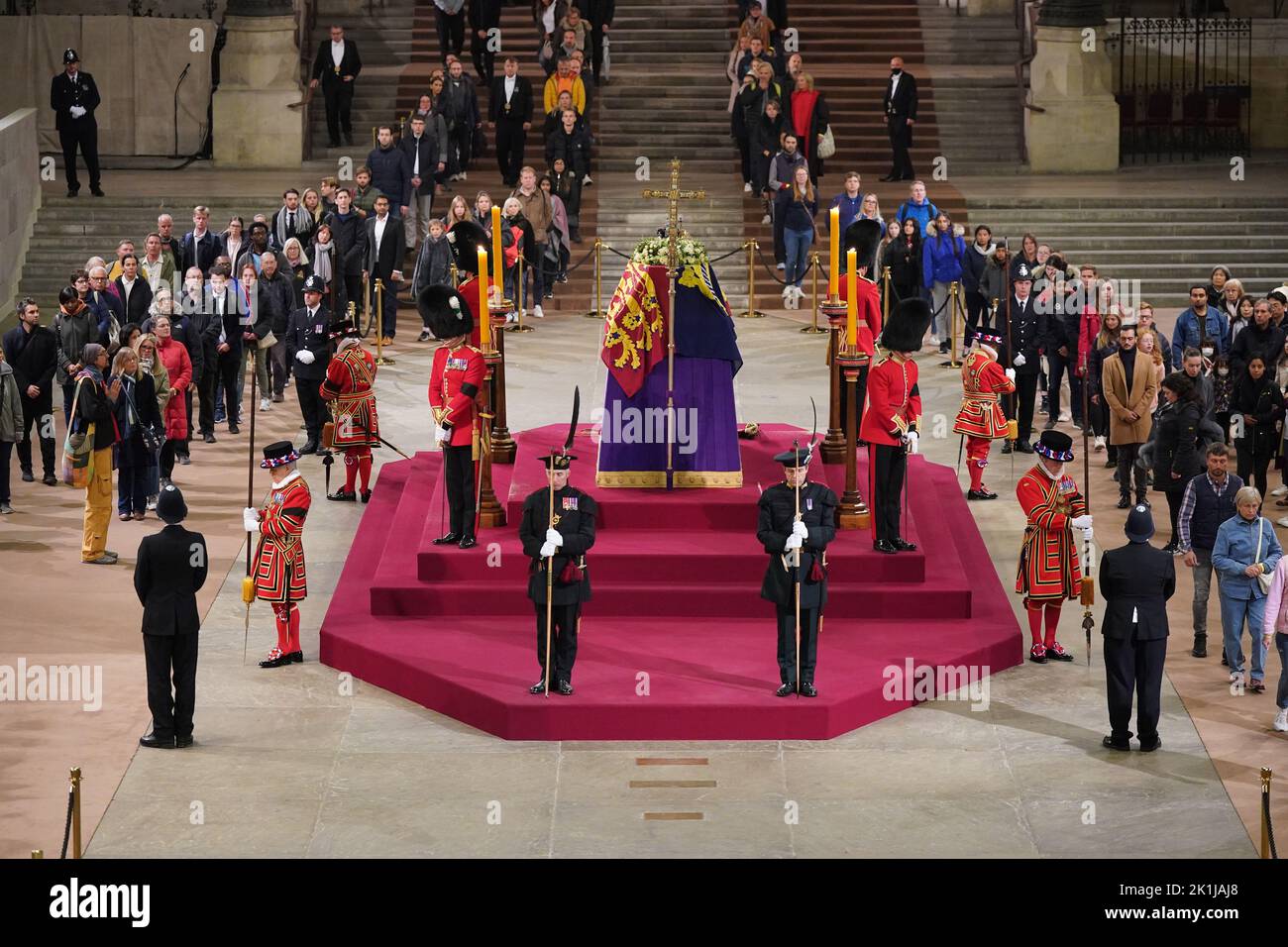 At 4.57am on the day of her funeral the final members of the public pay their respects at the coffin of Queen Elizabeth II, draped in the Royal Standard with the Imperial State Crown and the Sovereign's orb and sceptre, lying in state on the catafalque in Westminster Hall, at the Palace of Westminster, London. Picture date: Monday September 19, 2022. Stock Photo