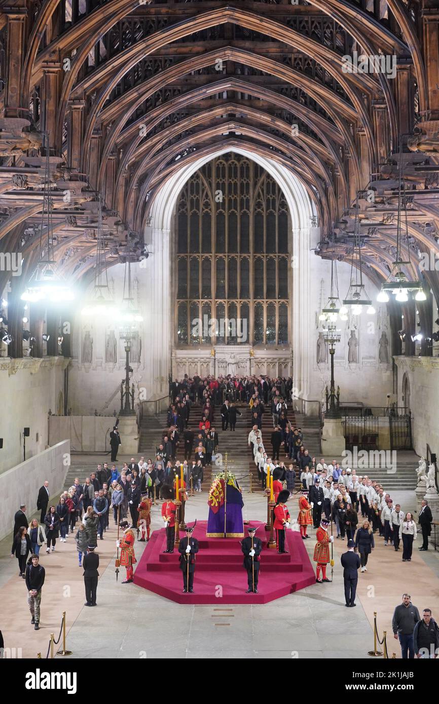 At 5.16am on the day of her funeral the final members of the public pay their respects at the coffin of Queen Elizabeth II, draped in the Royal Standard with the Imperial State Crown and the Sovereign's orb and sceptre, lying in state on the catafalque in Westminster Hall, at the Palace of Westminster, London. Picture date: Monday September 19, 2022. Stock Photo