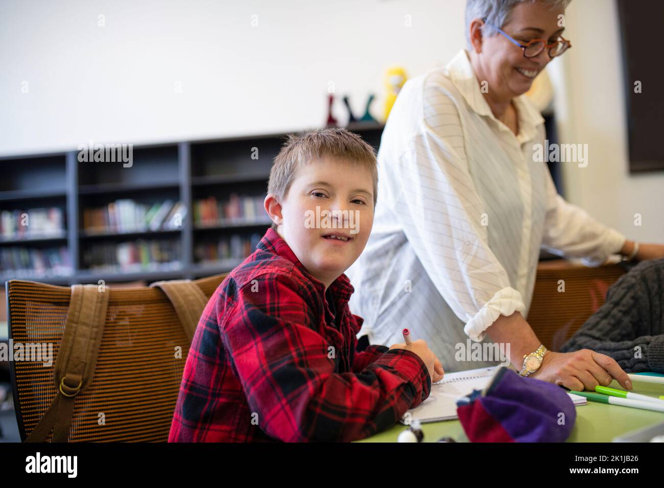 Portrait confident junior high boy with Down Syndrome studying in