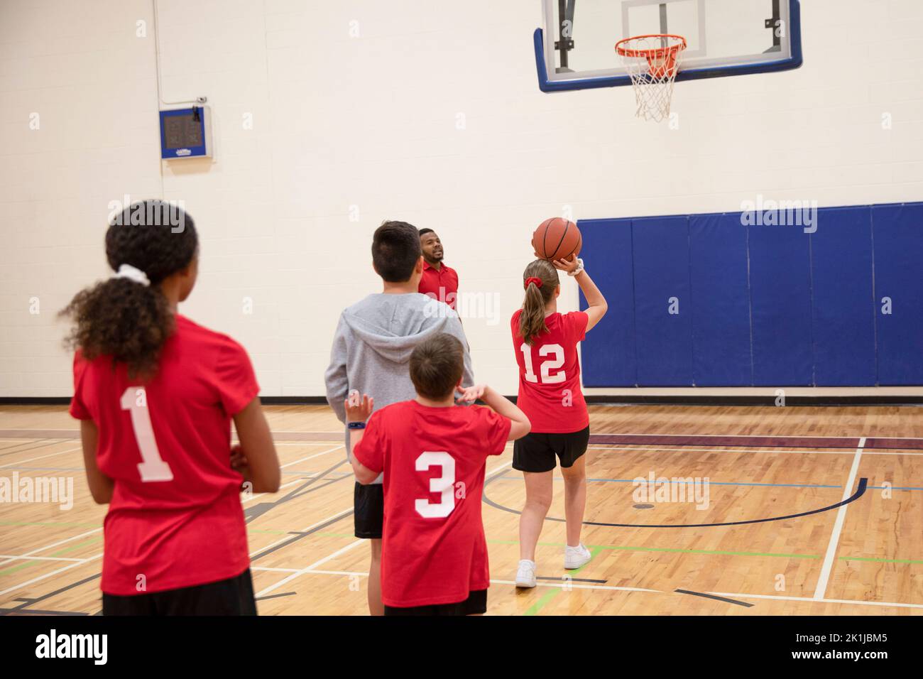 Junior high students playing basketball in gymnasium Stock Photo Alamy