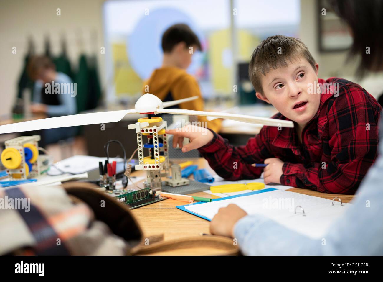 Junior high boy with Down Syndrome assembling wind turbine in classroom