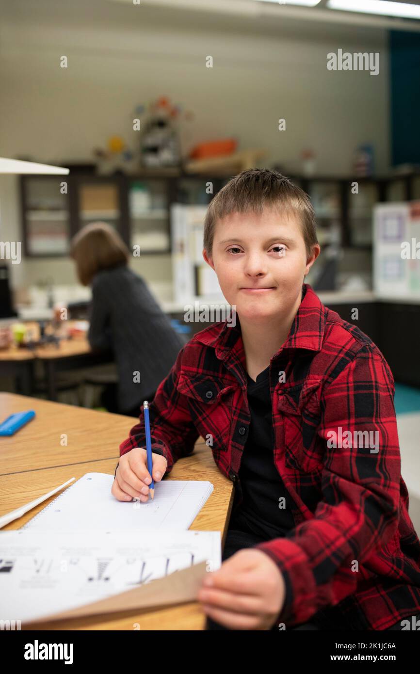 Portrait confident junior high boy with Down Syndrome studying in