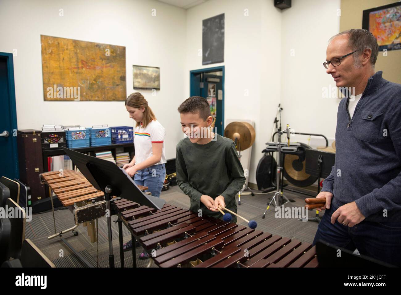 Happy junior high student playing xylophone in music class Stock Photo