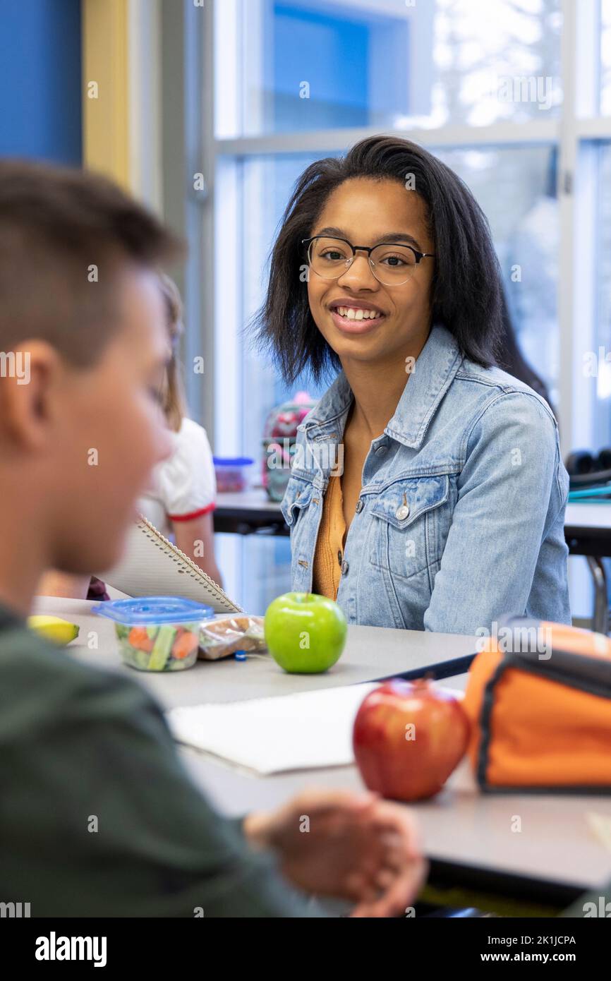 Portrait confident junior high girl student eating lunch in cafeteria