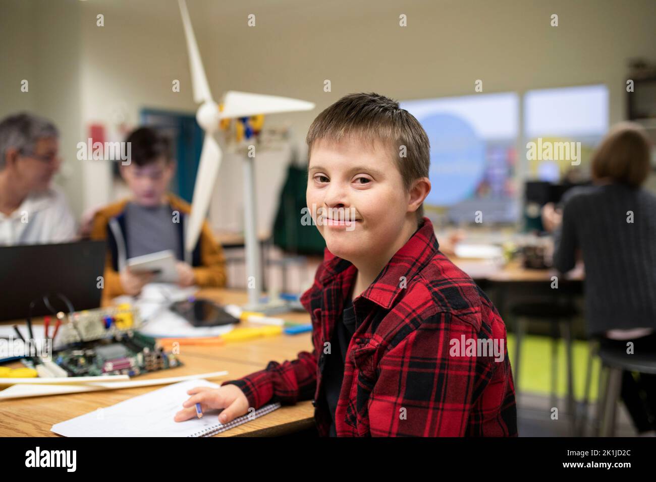 Portrait confident junior high boy with Down Syndrome in science