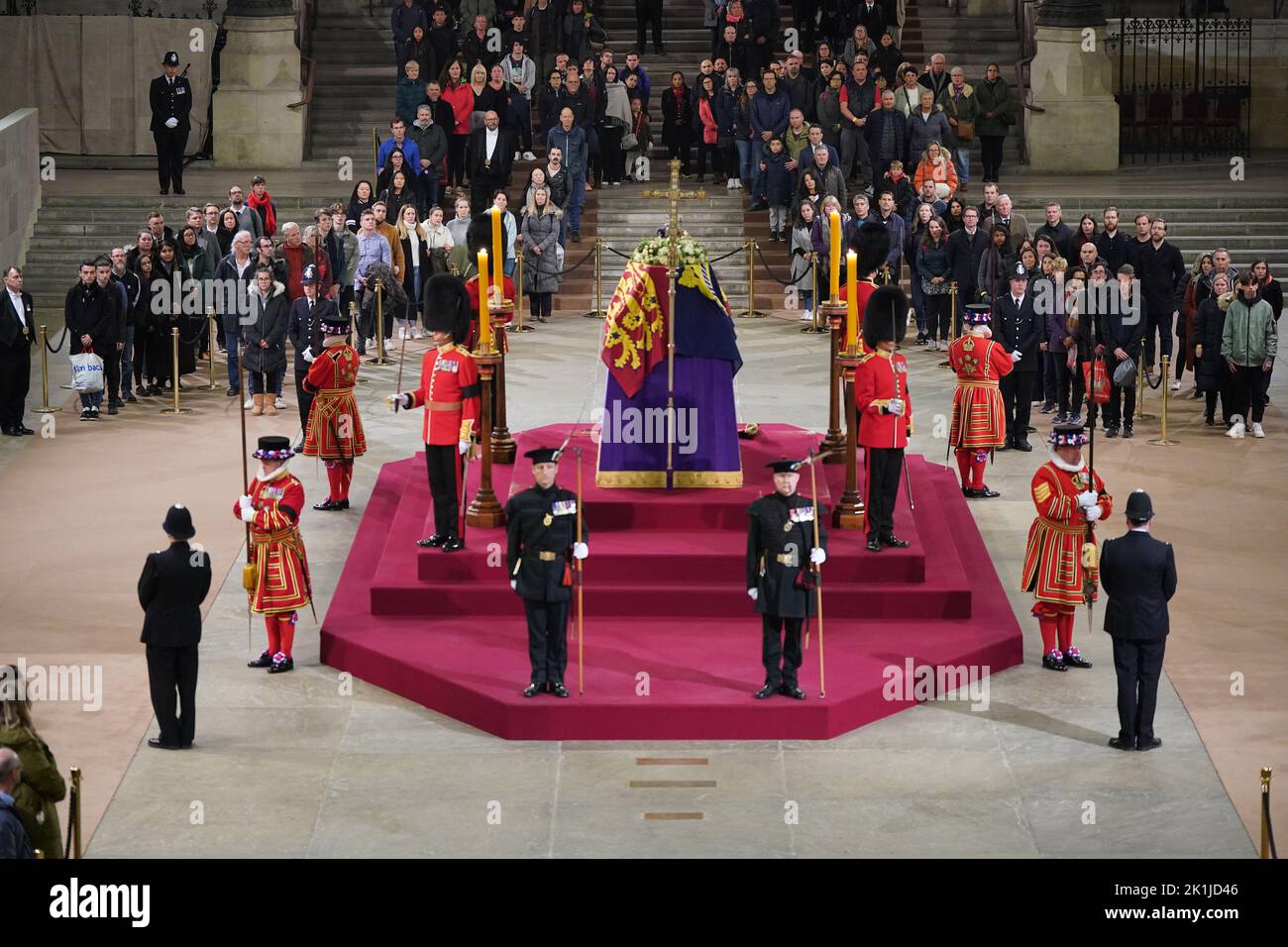 At 06:02am on the day of her funeral the final members of the public pay their respects at the coffin of Queen Elizabeth II, draped in the Royal Standard with the Imperial State Crown and the Sovereign's orb and sceptre, lying in state on the catafalque in Westminster Hall, at the Palace of Westminster, London. Picture date: Monday September 19, 2022. Stock Photo