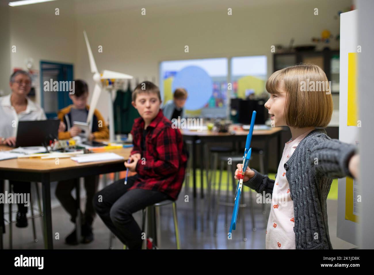 Junior high girl student presenting science experiment in classroom