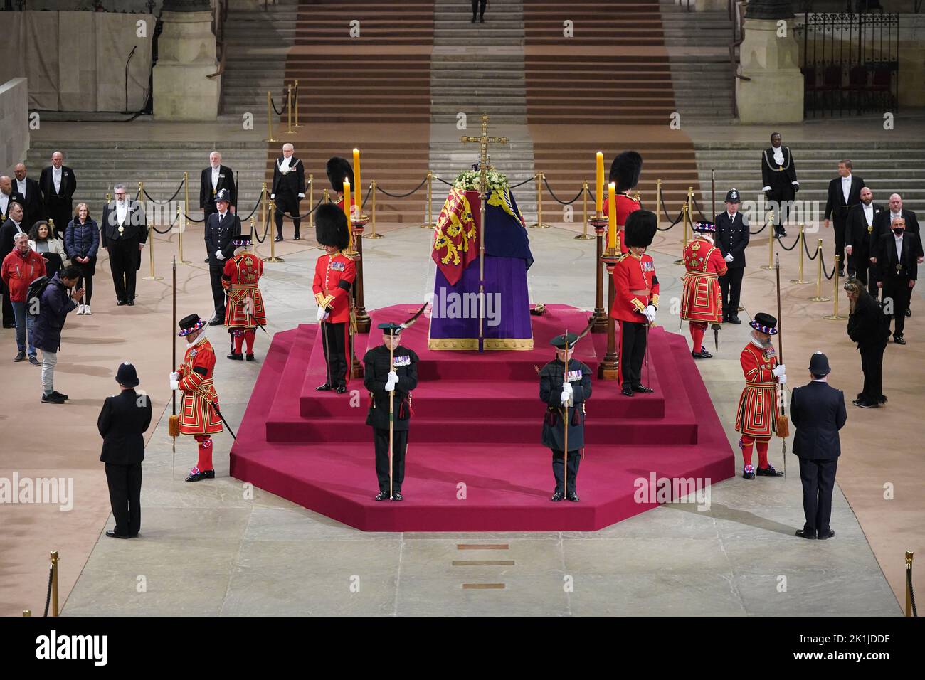 At 06:28am on the day of her funeral the final members of the public pay their respects at the coffin of Queen Elizabeth II, draped in the Royal Standard with the Imperial State Crown and the Sovereign's orb and sceptre, lying in state on the catafalque in Westminster Hall, at the Palace of Westminster, London. Picture date: Monday September 19, 2022. Stock Photo
