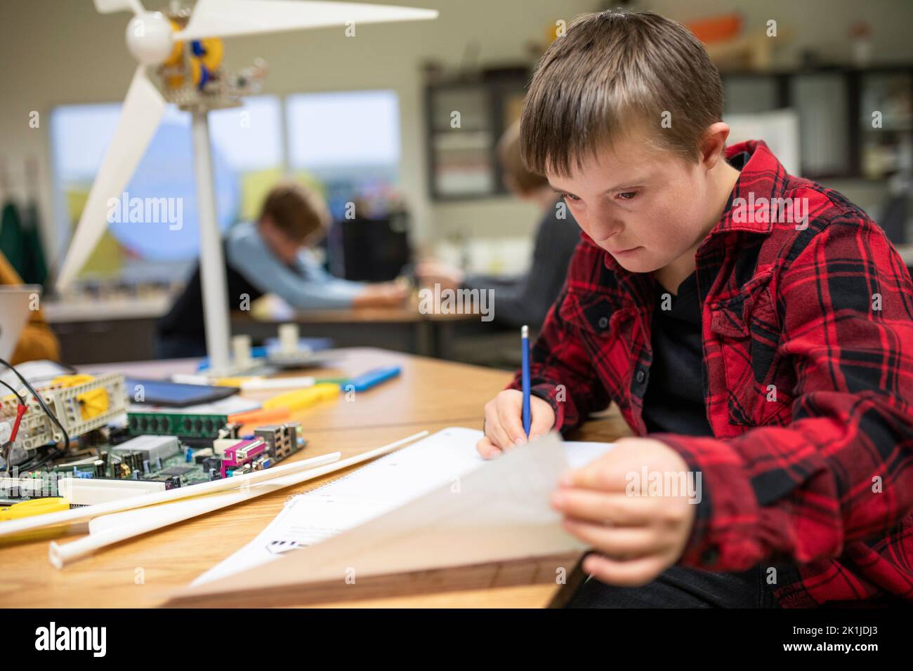 Focused junior high boy with Down Syndrome studying in science
