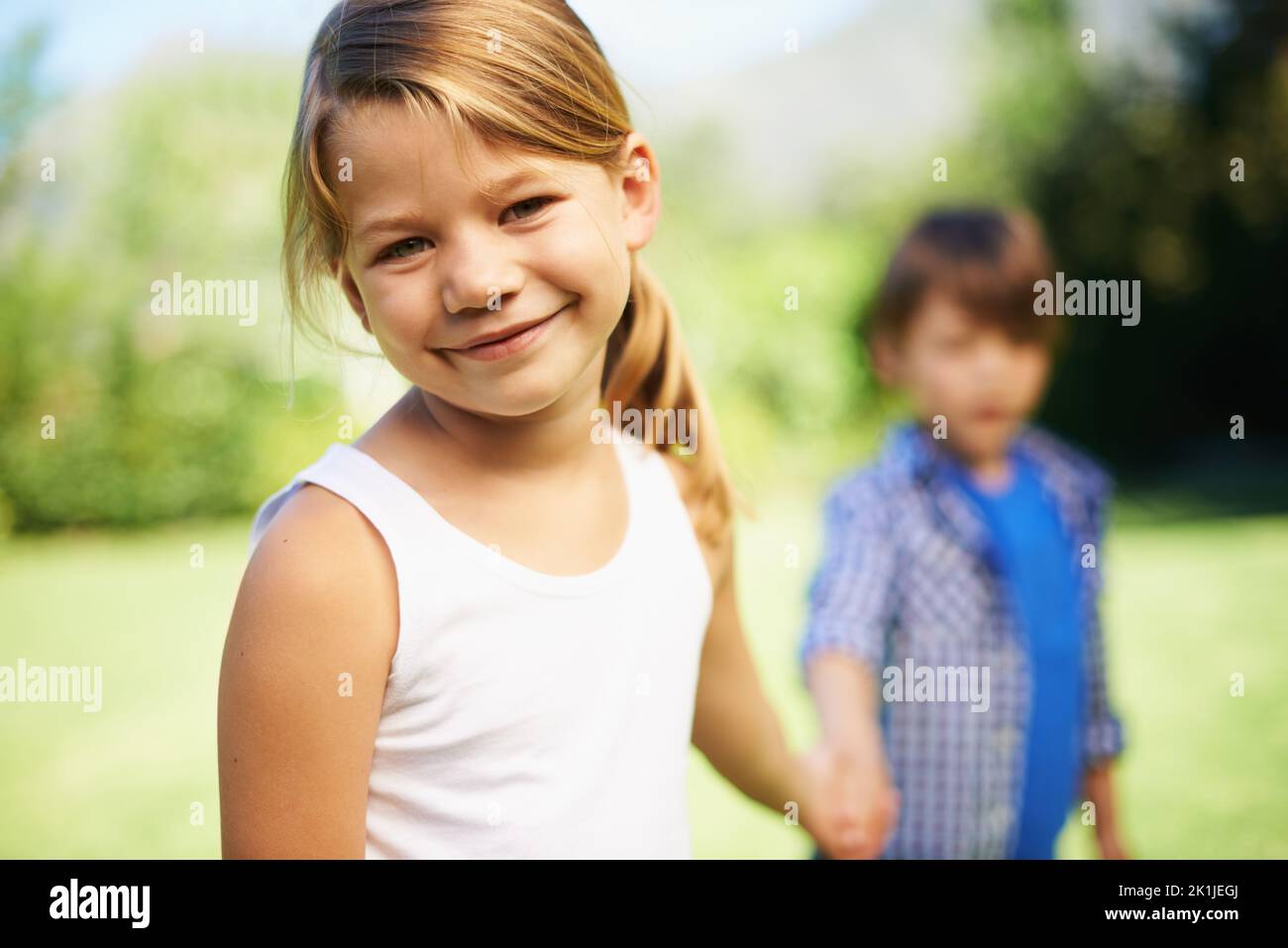Come on lets go play. a young girl and boy holding hands Stock Photo ...