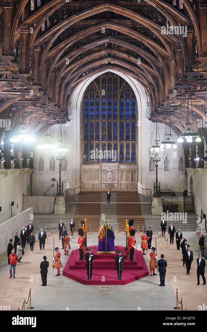 At 06:28am on the day of her funeral the final members of the public pay their respects at the coffin of Queen Elizabeth II, draped in the Royal Standard with the Imperial State Crown and the Sovereign's orb and sceptre, lying in state on the catafalque in Westminster Hall, at the Palace of Westminster, London. Picture date: Monday September 19, 2022. Stock Photo
