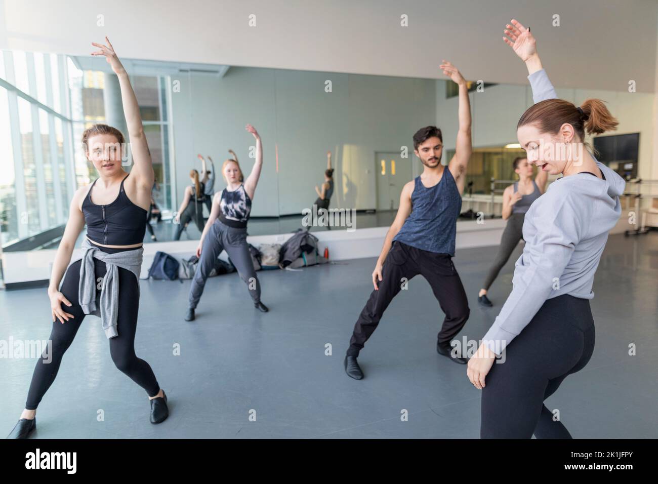 Instructor guiding dance students rehearsing in dance studio Stock Photo