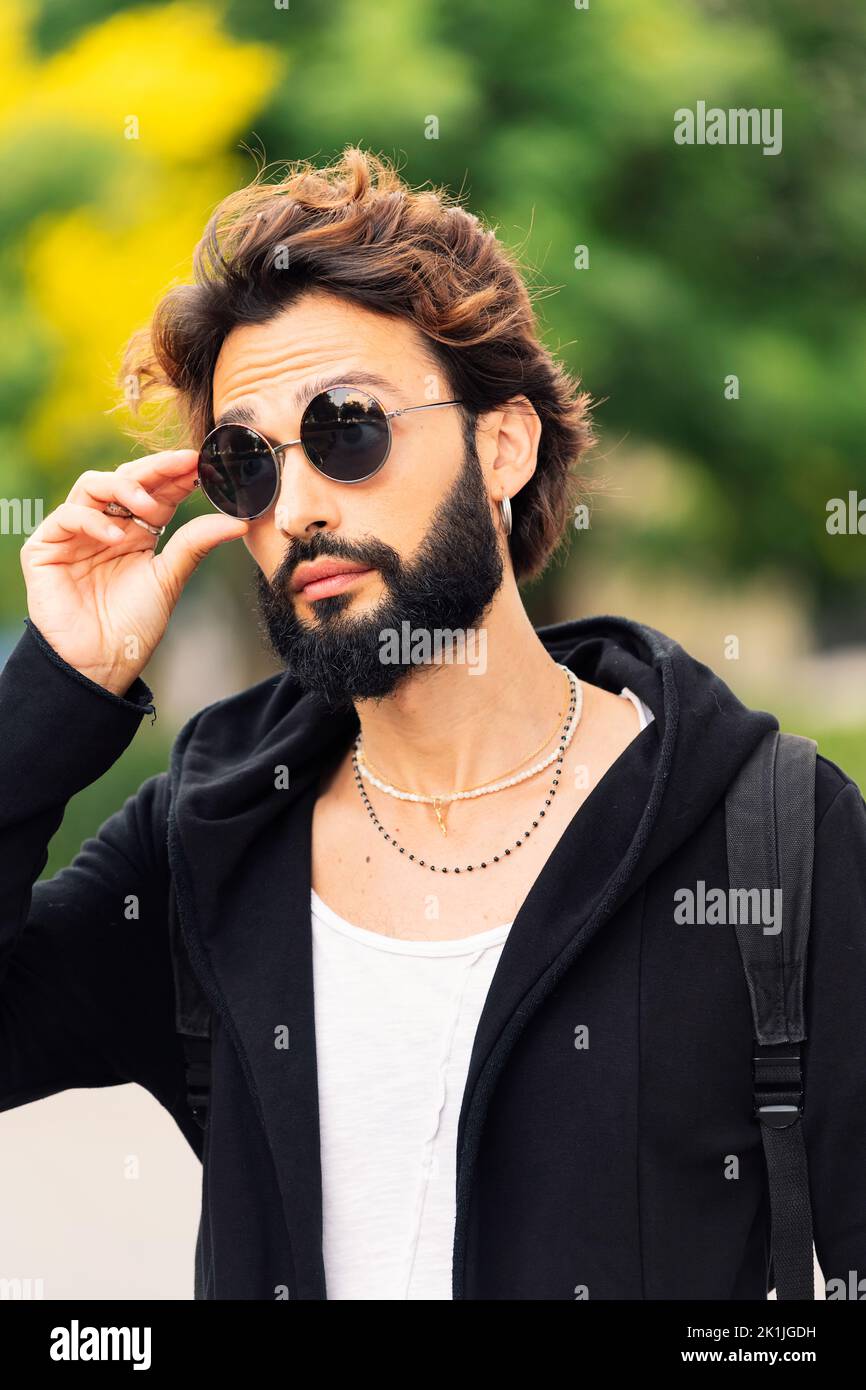 stylish young man with beard putting on sunglasses Stock Photo - Alamy